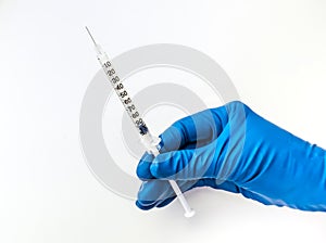 Doctor`s hand in blue medical glove holding open syringe with medical solution isolated white background. Flu vaccine