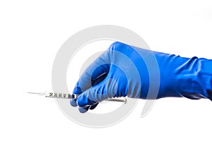 Doctor`s hand in blue medical glove holding open syringe with medical solution isolated white background. Flu vaccine