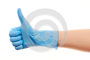 Doctor's hand in blue surgical glove showing thumbs up sign