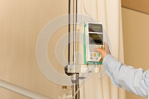 Doctor `s hand control IV on infusion pump intravenous IV drip i