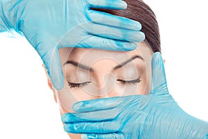 Doctor`s hand in gloves around eyes of a girl