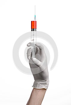 Doctor's hand holding a syringe, white gloved hand, a large syringe, the doctor makes an injection, white background