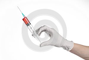 Doctor's hand holding a syringe, white gloved hand, a large syringe, the doctor makes an injection, white background