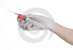 Doctor's hand holding a syringe, white gloved hand, a large syringe, the doctor makes an injection, white background