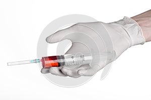 Doctor's hand holding a syringe, white gloved hand, a large syringe, the doctor makes an injection, white background