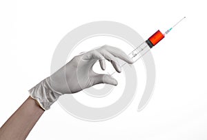 Doctor's hand holding a syringe, white gloved hand, a large syringe, the doctor makes an injection, white background