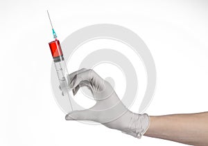 Doctor's hand holding a syringe, white gloved hand, a large syringe, the doctor makes an injection, white background