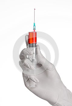 Doctor's hand holding a syringe, white gloved hand, a large syringe, the doctor makes an injection, white background