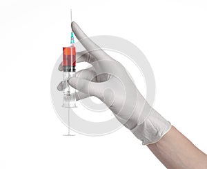 Doctor's hand holding a syringe, white gloved hand, a large syringe, the doctor makes an injection, white background