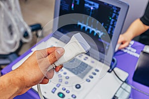 Doctor`s hand holding ultrasound probe of ultrasound scanner for medical diagnostics