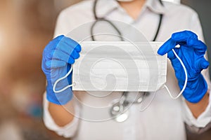 Doctor`s hand with a medical face mask for protection against infection