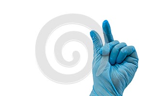 Doctor`s hand in sterile medical gloves shows a gesture of `little` two fingers with fingers isolated on a white background. Pande