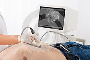 Doctor`s Hand With Ultrasound Scan On Abdomen Of Male Patient