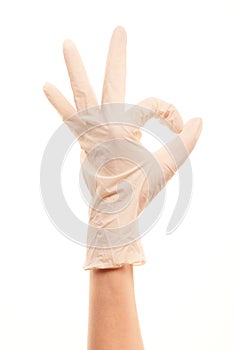 Doctor's hand in white sterilized surgical glove showing OK sign