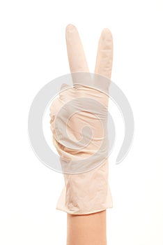 Doctor's hand in white sterilized surgical glove showing victory sign