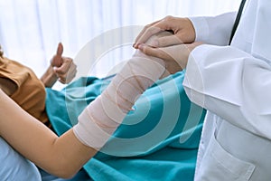 Doctor`s hands holding female patient`s hand for encouragement and empathy. Partnership