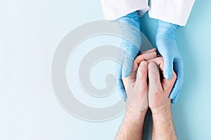 Doctor`s hands holding man`s hands.