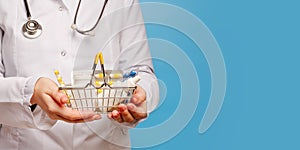 Doctor`s hands are holding shopping cart with various pills and tablets