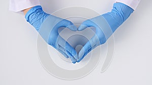 Doctor's hands in medical gloves making shape of heart on white background with copy space.