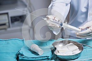 Doctor`s hands that is preparing an amniocentesis needle for amniotic fluid extraction