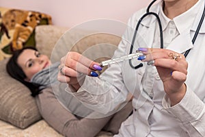 Doctor`s hands with termometr and ill patient