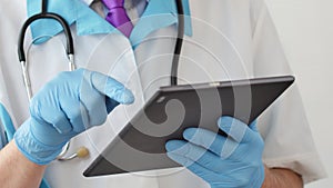 Doctor`s hands typing on modern digital tablet. Concept of modern healthcare