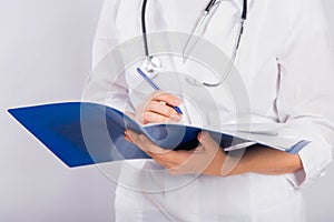 Doctor`s hands in a white coat hold a folder and fill out a medical document close-up isolated on a white background.