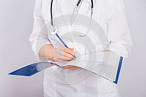 Doctor`s hands in a white coat hold a folder and fill out a medical document close-up isolated on a white background.