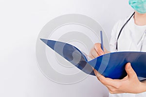 Doctor`s hands in a white coat hold a folder and fill out a medical document close-up isolated on a white background.