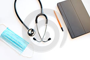 Doctor`s table at medical clinic. Stethoscope, mask and digital tablet.