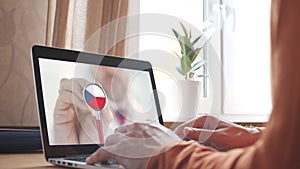 Doctor`s video call on the laptop at home, stethoscope bell with the Czech flag. Telemedicine in Czech Republic