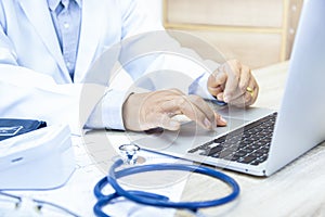 Doctor`s workplace with a laptop has a stethoscope ,Blood pressure monitor and medical documents on white table top view image.