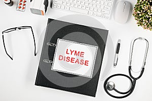 Doctor`s workspace, in the center is a folder with the inscription: lyme disease