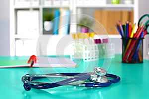 Doctor`s workspace working table with patient`s discharge blank paper form, medical prescription, stethoscope on desk