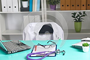 Doctor`s workspace working table with patient`s discharge blank paper form, medical prescription, stethoscope on desk