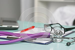 Doctor`s workspace working table with patient`s discharge blank paper form, medical prescription, stethoscope on desk