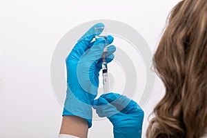 Doctor scientis in protective gloves holding glass vial with injection liquid. Vaccination against influenza and coronavirus