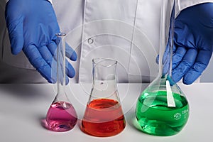 Doctor Scientist Shows Colored Chemical Flasks - Labs Photo