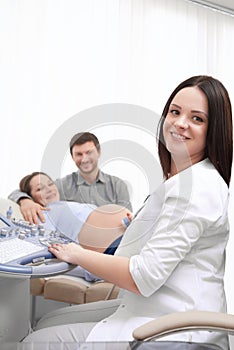 Doctor screening pregnant woman and press buttons on special computer.