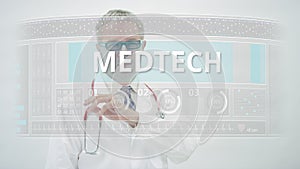 Doctor scrolls to MEDTECH tab on a modern medical display photo