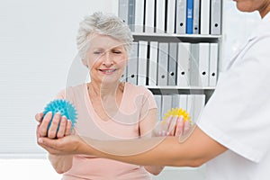 Doctor with senior patient using stress buster balls