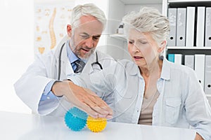 Doctor with senior patient using stress buster balls