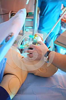 The doctor sets oxygen mask on dummy patients