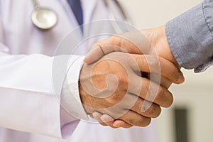 Doctor shakes hands with a patient photo