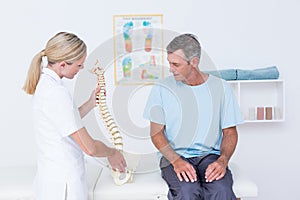 Doctor showing anatomical spine to her patient