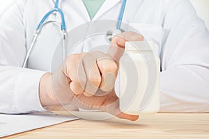 Doctor Showing A Bottle Of Pills To The Patient. specialist holding big jar of supplements, nutrition rich in vitamins. Doctor