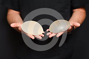 A doctor showing breast augmentation implants in her hands