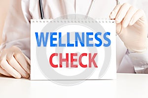 Doctor showing a card with text WELLNESS CHECK, medicine concept