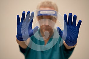 Doctor showing clean blue gloves to the viewer