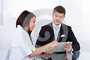Doctor showing digital tablet to businessman